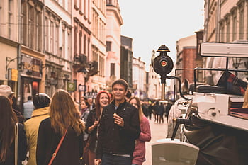 people walking, roadway, between buildings, bustling street, historic carriage, day out, street scene, urban life, cityscape, outdoor activity, historic setting