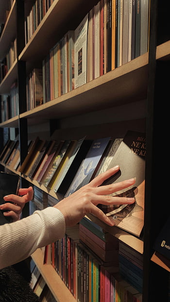 library, bookshelf, hands, selecting books, diverse titles, library setting, book browsing, book selection, reading, book collection, book lover