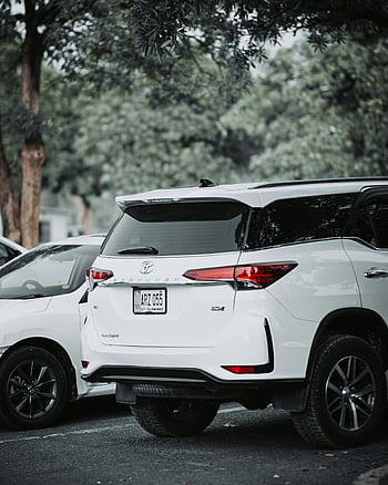 white Toyota Fortuner, parking lot, outdoor parking, lush green setting, luxury vehicle, style car, white SUV, Toyota Fortuner rear, car in nature, modern SUV, parked car