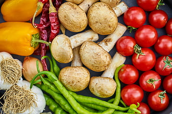 flat-lay photography, variety of vegetables, vibrant assortment, fresh vegetables, mushrooms, tomatoes, bell peppers, green peppers, garlic, onions, chili peppers