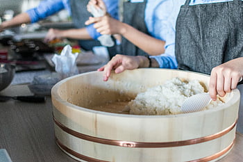sushi rice, chefs, modern kitchen, white plastic ladle, food preparation, wooden bowl, rice preparation, cooking class, culinary arts, sushi making, kitchen setting