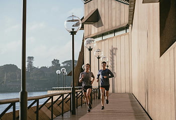 uomo e donna jogging, Teatro dell'opera di Sydney, giorno soleggiato, uno stile di vita sano, esercizio all'aperto, fitness, coppia che corre, lungomare, Australia, vita attiva, jogging mattutino