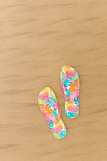 flip flops, beach sand, floral print, vibrant colors, sandy beach, top view, summer footwear, beach accessories, tropical design, beach slippers, beach shoes