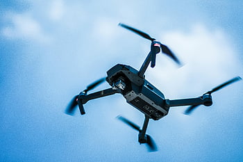 Gray quadcopter, sky, sleek drone, clear blue background, modern technology, action, flying drone, aerial photography, quadcopter in flight, blue sky, drone technology
