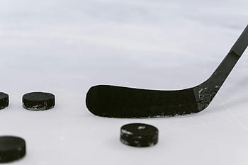 hockey puck, hockey stick, close up shot, detailed view, sports visuals, ice surface, sports equipment, hockey equipment, ice rink, sports photography, hockey game