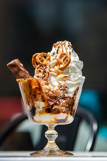 Sundae au caramel au chocolat, crème fouettée, bretzels, Coupe en verre, dessert, l'eau à la bouche, gâterie sucrée, la crème glacée Sundae, sauce caramel, garniture au chocolat, tasse de dessert en verre