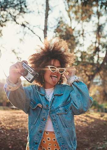 sluneční brýle, Veselá žena, džínové bundy, Fotoaparát, usmívající se, venku, afro vlasy, móda, životní styl, Příroda, zábava