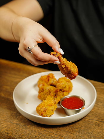 crispy chicken wings, fried chicken, chicken wing, sauce, wooden table, hand holding, crispy fried, dipping sauce, plate, food photography, appetizer
