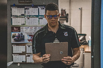 muž drží schránku, Skladový pracovník, Kontrola dokumentů, Plánování logistiky, vážný pracovník, Schránka, vnitřní pokoj, Interiér skladu, Přezkum dokumentu, pracovník v uniformě