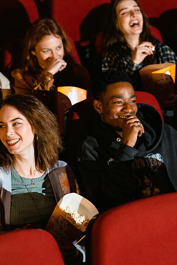 movie theater, diverse friends, buckets of popcorn, watching movie, laughing, enjoying popcorn, theater seats, group of friends, movie night, cinema experience, red seats
