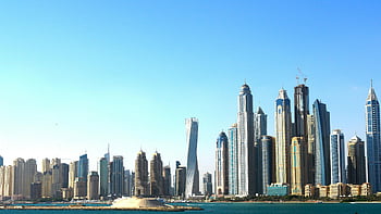 Dubai Wolkenkratzer, Skyline der Stadt, klarer Himmel, Blick aufs Wasser, hoch aufragende Gebäude, lebendiger blauer Himmel, Panorama -Stadtbild, moderne Architektur, städtische Landschaft, Dubai Marina, Hoch hinausragende Gebäude