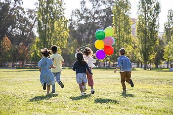děti si hrají, balóny, zelené louky, slunečný park, přátelství, radost, děti běží, venkovní zábava, barevné balónky, šťastné děti, příroda hrát