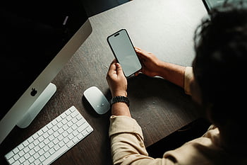 woman using computer, smart phone, desk setup, computer mouse, smartphone screen, working at desk, technology use, multitasking, office environment, digital device, person working