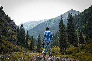 photographer, mountain landscape, Ak-Talaa, Kyrgyzstan, blue and white checked shirt, black camera, standing on rock, serene, outdoor photography, nature, adventure