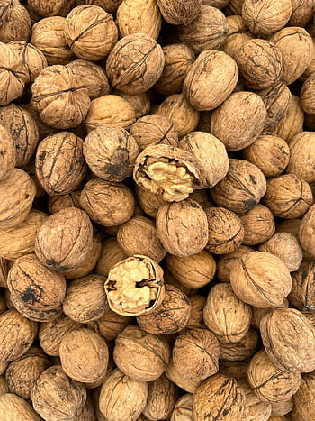pile of walnuts, high-resolution image, cracked walnuts, walnut texture, walnut detail, walnut close-up, walnut pile, walnut shell, walnut kernel, walnut nuts, walnut photo