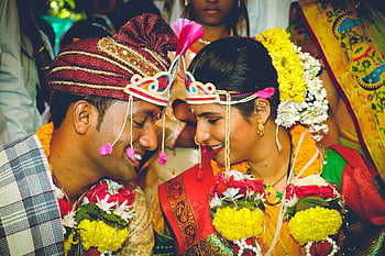 mariage indien, tenue colorée, couple souriant, tenue traditionnelle, cérémonie dynamique, homme et femme, se faire face, guirlandes de fleurs, célébration culturelle, occasion festive, Couple heureux
