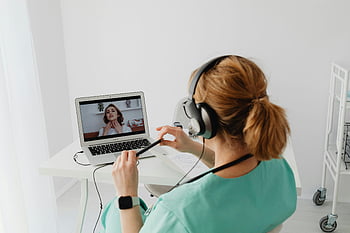 woman in teal scrub suit, video call, doctor online consultation, laptop, modern office setting, patient consultation, healthcare professional, virtual meeting, medical consultation, headset, telemedicine