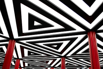 black and white triangle pattern, geometric pattern, abstract design, red columns, striking design, triangle shapes, black and white, red accents, modern art, geometric art, abstract photography