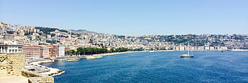 Naples cityscape, coastline view, sailboats, sunny day, panoramic view, blue sea, daytime, city buildings, waterfront scene, Italian coast, Mediterranean sea