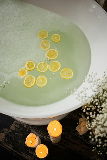 Bad mit Zitronenscheiben, Entspannende Badewanne, Zitronenscheiben im Wasser, Beruhigende Spa -Erfahrung, Kerzen, Badkerzen, Spa -Bad, Badewanne mit Kerzen, Zitronenbad, Entspannungsbad, Spa -Entspannung