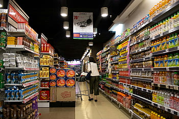 woman pushing cart, supermarket aisle, shopper, Jawa Timur, Indonesia, vibrant scene, grocery store, shopping cart, product shelves, beverage aisle, promotional signs