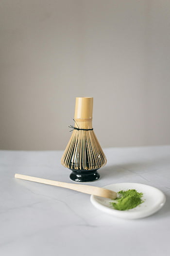 matcha čaj, bambusový šlehač, příprava na matchu, Prášek ze zeleného čaje, minimalistické nastavení, bílé pozadí, bambusová špachtle, Příprava Matcha, čajový ceremoniál, ingredience na matchu, nástroje pro přípravu matchy