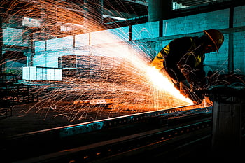 industrial worker, angle grinder, cutting steel, bright sparks, factory setting, metal cutting, sparks flying, steel cutting, worker safety, industrial environment, factory worker