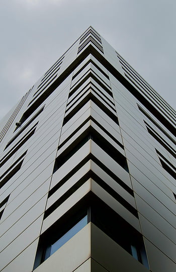 moderner Wolkenkratzer, geometrische Muster, schlanke Architektur, Flachwinkelansicht, zeitgenössisches Gebäude, städtische Skyline, Architekturdesign, Stadtbild, modernes Gebäude, Geometrische Architektur, Himmel Hintergrund