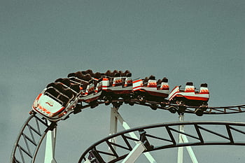 roller coaster, vintage cars, clear sky, amusement park, thrilling ride, outdoor attraction, entertainment, funfair, vintage roller coaster, action shot, striking view