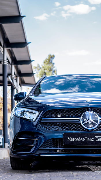 Blue Mercedes-Benz, parked street, luxury car, Gaborone Botswana, outdoor parking, sleek design, Mercedes-Benz logo, car photography, automotive elegance, street scene, Mercedes-Benz vehicle