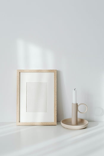 bougie en cire, cadre en bois, composition minimaliste, Lumière douce, design élégant, cadre vide, bougeoir, fond blanc, décor moderne, décoration de maison, Art minimaliste
