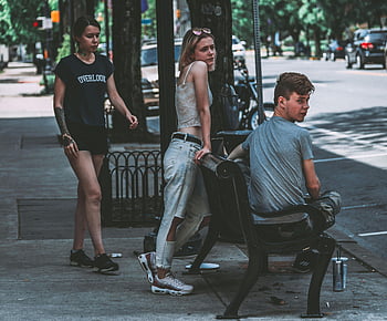 tre persone, marciapiede, giovani adulti alla moda, strada urbana, abbigliamento casual, giorno soleggiato, banco di strada, vita di città, scena all'aperto, moda casual, stile di strada