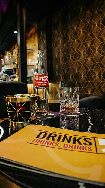 pub table, drinks on table, stylish bar setting, reflective table, elegant menu, bar decorations, cozy bar environment, pub atmosphere, cocktail table setting