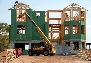 construction site, yellow crane, heavy equipment, unfinished building, multi-story house, wooden construction, sunny day, building under construction, construction crane, construction machinery, green building materials