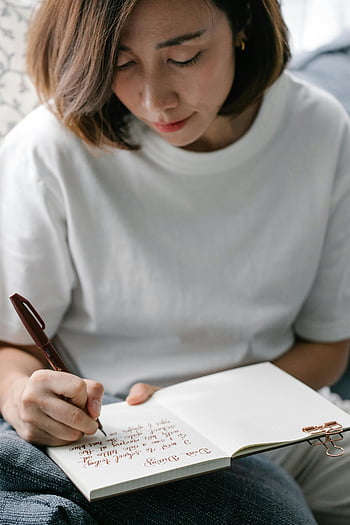 woman writing, diary, journal, personal thoughts, indoor, notes, writing notes, woman indoors, white shirt, focused, pen
