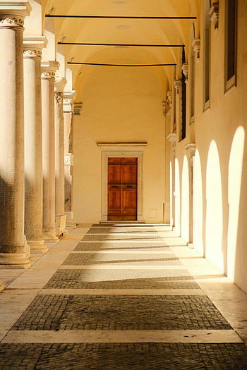 Elegante corridoio, corridoio soleggiato, corridoio porticato, porta di legno, Vista architettonica, archi, architettura senza tempo, interior design, edificio storico, colonne di pietra, luce naturale