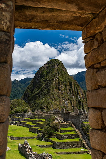 Machu Picchu, ancient stone architecture, vibrant sky, mountain view, Inca ruins, Peru, historical site, natural landscape, travel destination, scenic view, stone window frame