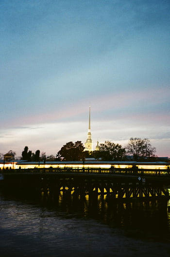 Peter and Paul Fortress, twilight view, river reflection, serene landscape, beautiful sky, building near water, evening photography, historic architecture, waterfront scene, St. Petersburg, Russia