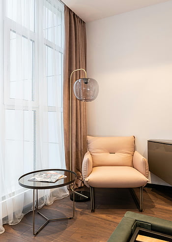Stilvoller Raum, Neue Möbel, gemütlicher Sessel, Beistelltisch, stilvoll gestaltet, Wohnzimmer, Entspannung, moderne Einrichtung, Innenarchitektur, bequeme Sitzgelegenheiten, zeitgenössische Möbel