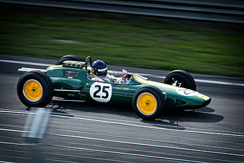 green vintage Formula 1 car, number 25, classic racing heritage, racetrack, timelapse photography, green racing vehicle, vintage racing car, Team Lotus, racing lane, Formula 1, green and white racing vehicle