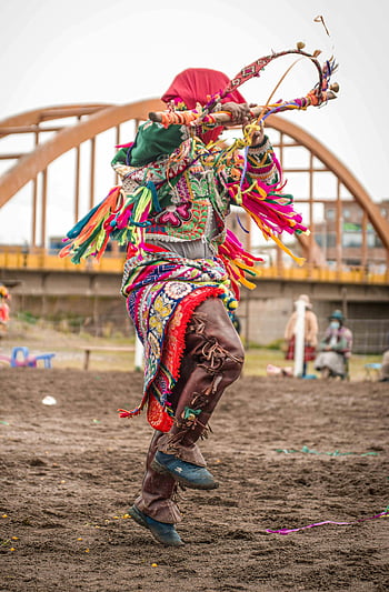 man dancing, brown soil, vibrant dancer, traditional Peruvian attire, performing outdoors, Cusco, cultural dance, colorful costume, outdoor performance, traditional dance, Peruvian culture