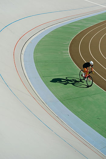 cyclist racing, outdoor velodrome track, colorful track, Kyiv Ukraine, helmet, cycling, race track, sports, athlete, bicycle, competition