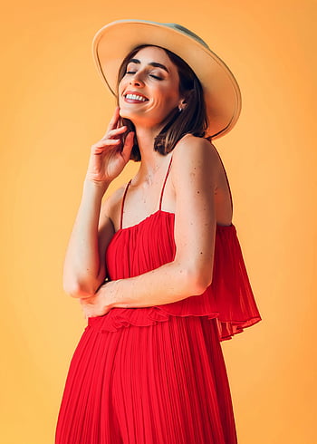 Frau im roten Kleid, rotes Kleid, Hut, stilvolle Frau, orange Hintergrund, Studioportrait, selbstbewusste Pose, Modefotografie, rotes Outfit, Frau mit Hut, Studioaufnahme