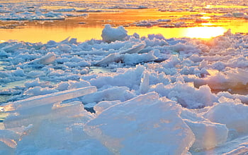 frozen lake, sunset, icy formations, warm glow, winter landscape, ice chunks, frozen water, winter sunset, icy scene, frozen nature, sunset over ice