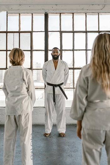 karate school, martial arts instructor, students practicing, well-lit dojo, large windows, karate practice, dojo interior, martial arts training, karate students, instructor teaching, dojo environment