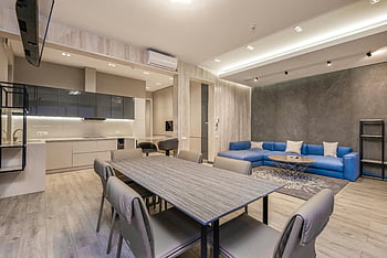 Moderne studiolejlighed, stilfuldt interiør, spisestue, blå sofa, Slank stue, Elegant indretning, køkken, moderne design, Åben layout, minimalistiske møbler