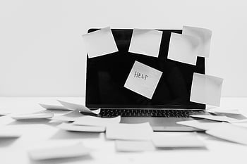 kartki samoprzylepne, laptop, obraz monochromatyczny, Chaos w miejscu pracy, zagracone biurko, Uwaga pomocy, Dezorganizacja biura, stres w pracy, problemy z wydajnością, Niechlujne miejsce robocze, bałagan papierowy