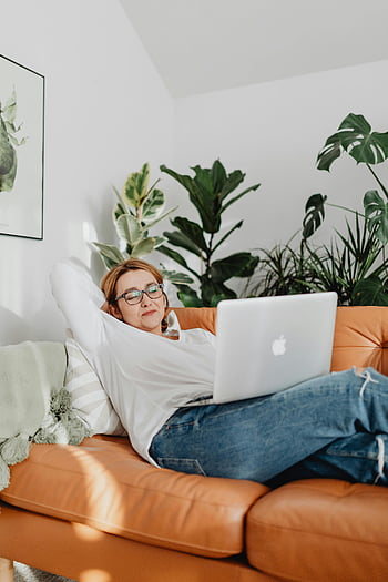 Kobieta odpoczywa, sofa, laptop, przytulny dom, rośliny, wylegiwać się, ustawienie wewnętrzne, wygodny, codzienny, Praca w domu, relaks