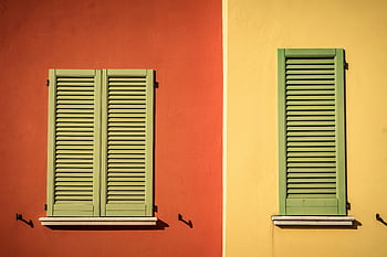 Green Louver Board, colorful shuttered windows, green louvers, orange walls, yellow walls, vibrant facade, shuttered windows, colorful windows, green shutters, architectural details, building facade