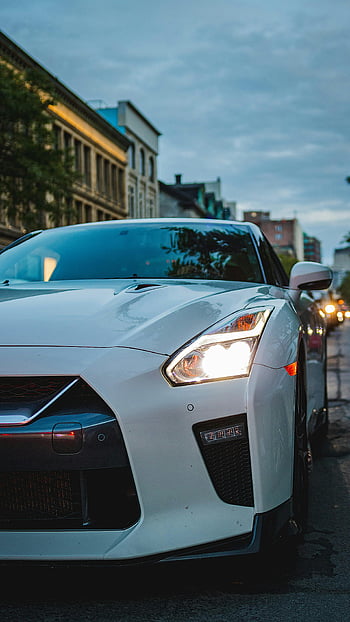 super car, white sports car, city street, dusk, headlights on, parked car, urban scene, luxury vehicle, high-performance car, automotive wallpaper, street photography